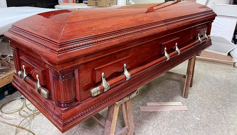 Polished wooden coffin fitted with metal swing bar handles produced by Virtue Hardware Co., Ltd
